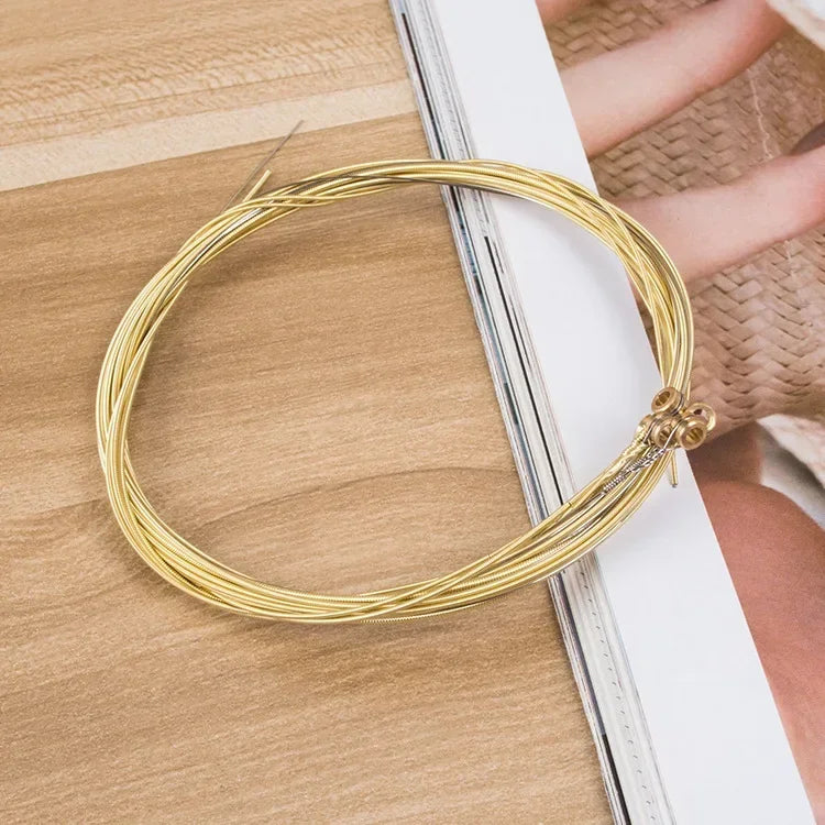 A coiled set of golden guitar string brass with hexagonal steel core securely bundled in a 6pcs set universal package