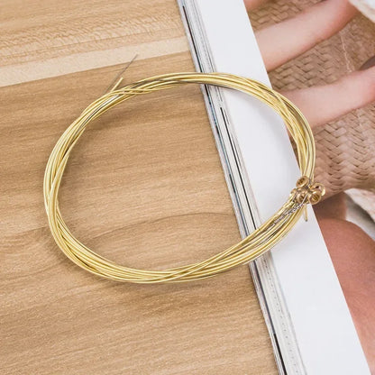 A coiled set of golden guitar string brass with hexagonal steel core securely bundled in a 6pcs set universal package