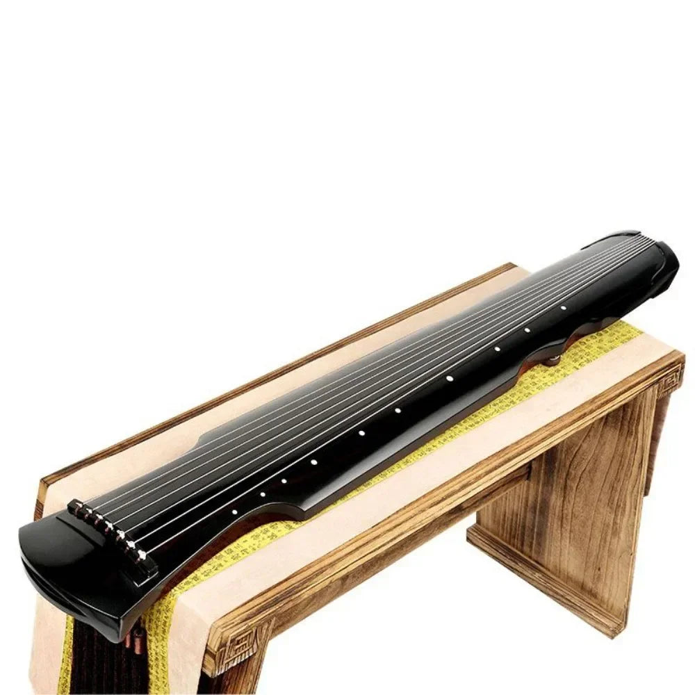 Black glossy wooden guqin zither handmade with seven strings and white dot inlays on light wood stand with accessories chinese traditional