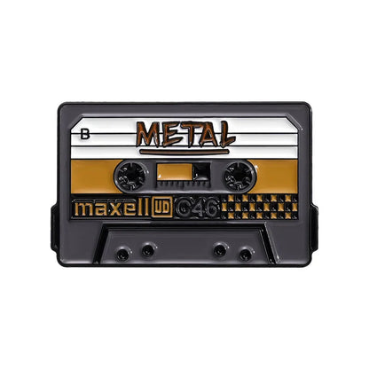 Black and gold enamel pin shaped like maxell ud c46 cassette tape with metal label from 90s retro music cassette tape collection