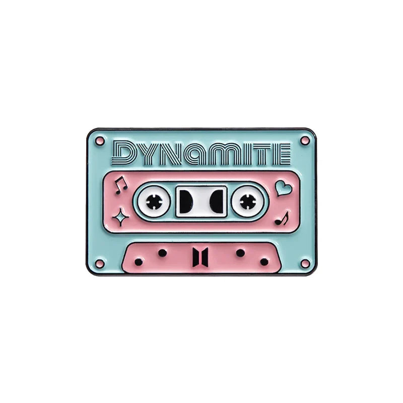 Pastel pink and mint green enamel pin shaped like a cassette tape with dynamite embossing from a 90s retro music collection
