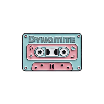 Pastel pink and mint green enamel pin shaped like a cassette tape with dynamite embossing from a 90s retro music collection