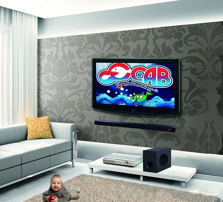 Black-framed flat-screen tv displaying pac-man game with 80w tv soundbar 2.1 bluetooth surround sound bar system