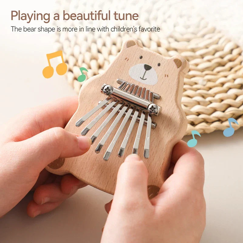 A light wood bear thumb piano kalimba with silver metal tines featuring a painted face for baby montessori toys and portable marimba musical use