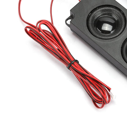 Black rectangular magnetic speaker with glossy cone and bundled red wiring designed for heavy bass audio use