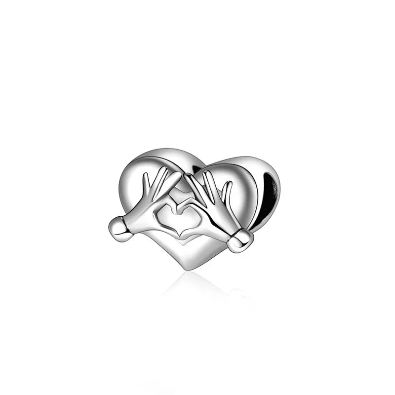 Silver heart-shaped sterling silver music charm with two hands forming a smaller heart for original bangle bracelet
