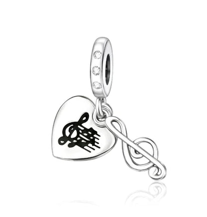 Silver sterling silver musical heart-shaped charm with engraved treble clef and dangling musical note for bracelet
