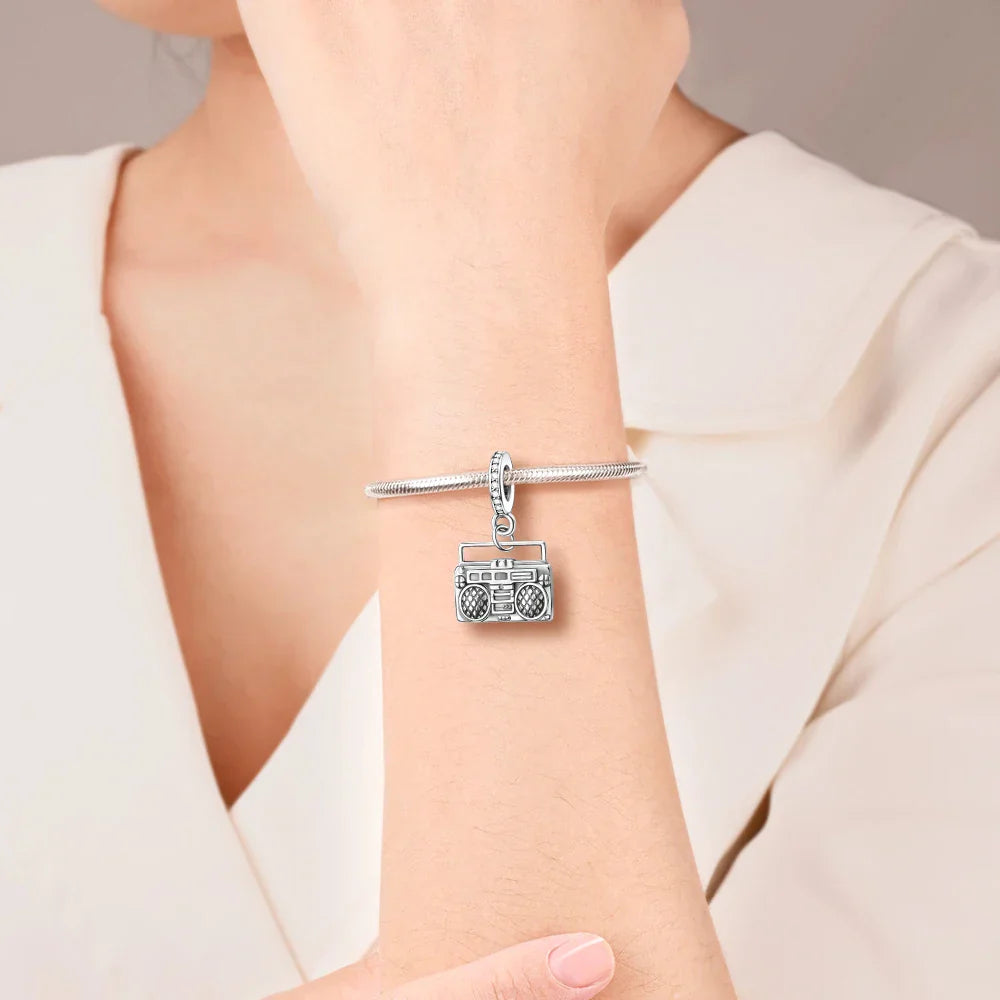Silver charm bracelet with detailed boombox pendant featuring intricate speaker grilles in sterling silver musical design
