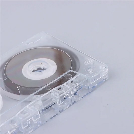 Clear plastic recordable clear audio cassette with silver spool and white hub for voice music recording use