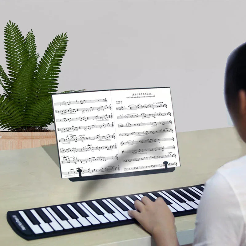 Adjustable and versatile music sheet stand with portable bookshelf holding sheet music beside a black and white flexible keyboard at beat music store