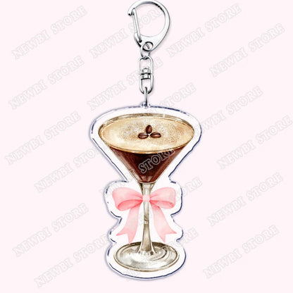 A clear acrylic aesthetic coquette pink keychain shaped like a martini glass with a pink bow and coffee beans for womens accessories ribbon and hot girl book club gifts