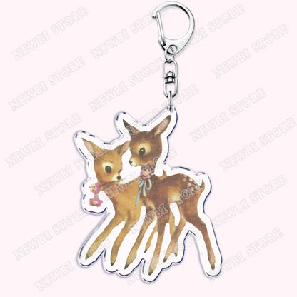 Clear acrylic keychain featuring two brown fawn deer with white outlines, floral details, aesthetic coquette pink womens accessories ribbon gift