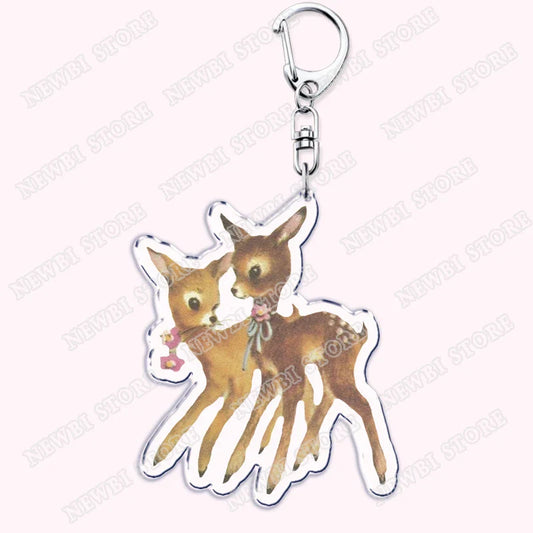 Clear acrylic keychain featuring two brown fawn deer with white outlines, floral details, aesthetic coquette pink womens accessories ribbon gift