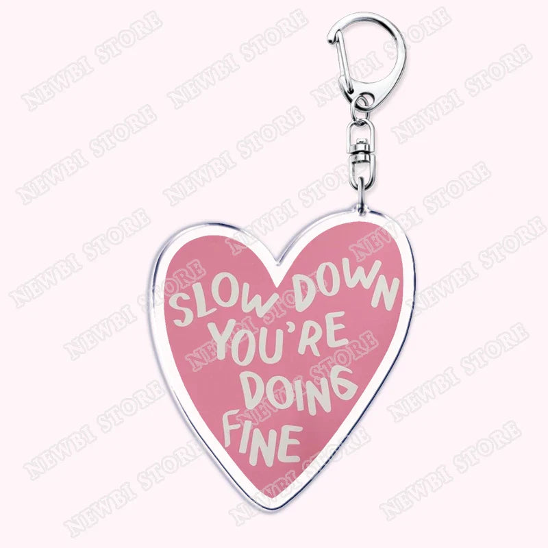 Pink heart-shaped keychain with silver border and clip featuring slow down youre doing fine for aesthetic coquette pink womens accessories ribbon hot girl book gifts