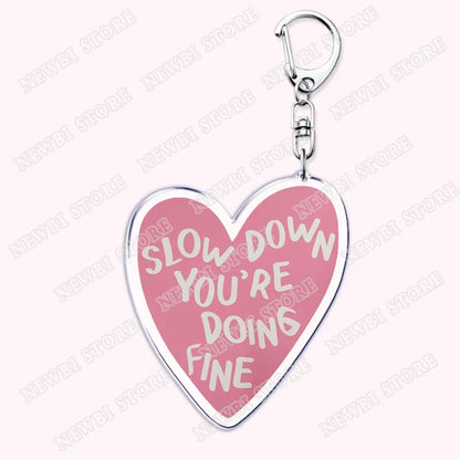 Pink heart-shaped keychain with silver border and clip featuring slow down youre doing fine for aesthetic coquette pink womens accessories ribbon hot girl book gifts