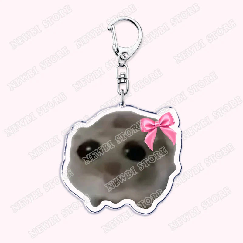 A silver-framed keychain with a gray cratered moon face and pink bow from aesthetic coquette pink womens accessories ribbon collection