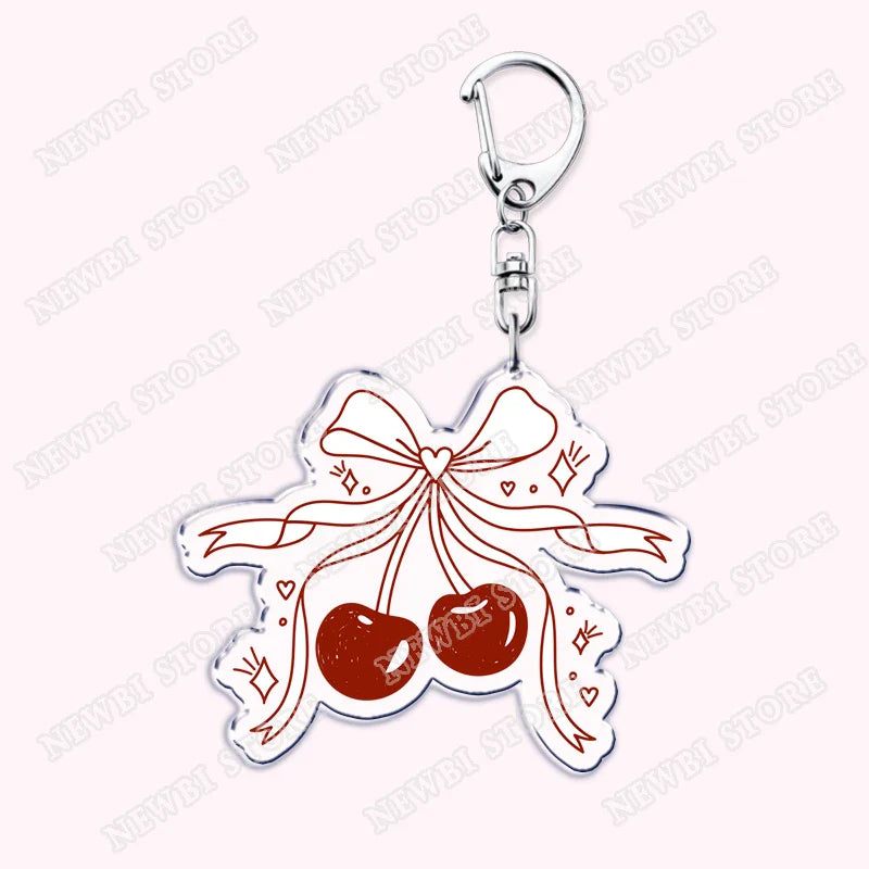A clear acrylic aesthetic coquette pink keychain with red cherries and white ribbon bow for womens accessories ribbon gifts