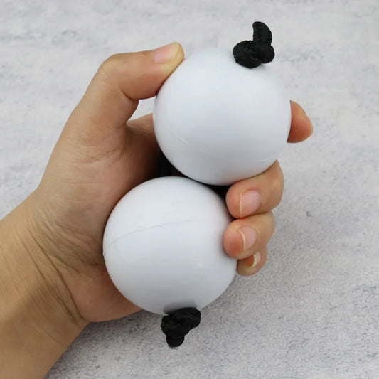 White spherical african shaker kashaka with black knotted details for rhythmic balls percussion music