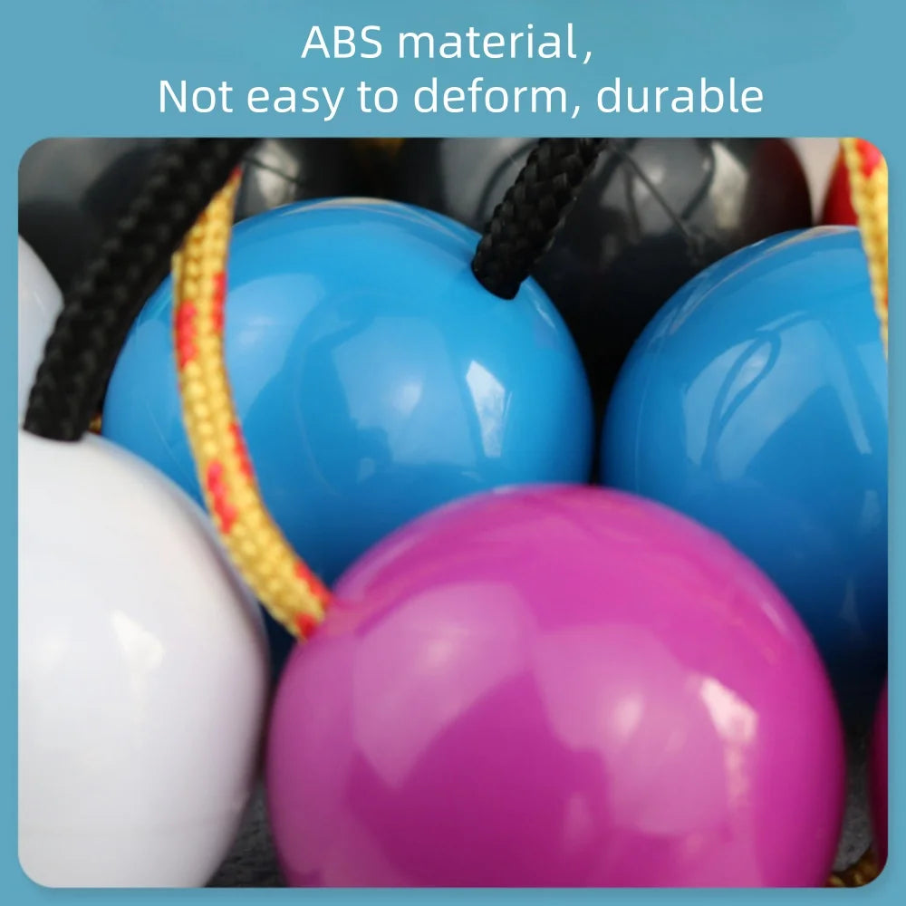 Brightly colored african shaker kashaka rhythmic balls in blue pink and white glossy abs plastic with braided rope handles