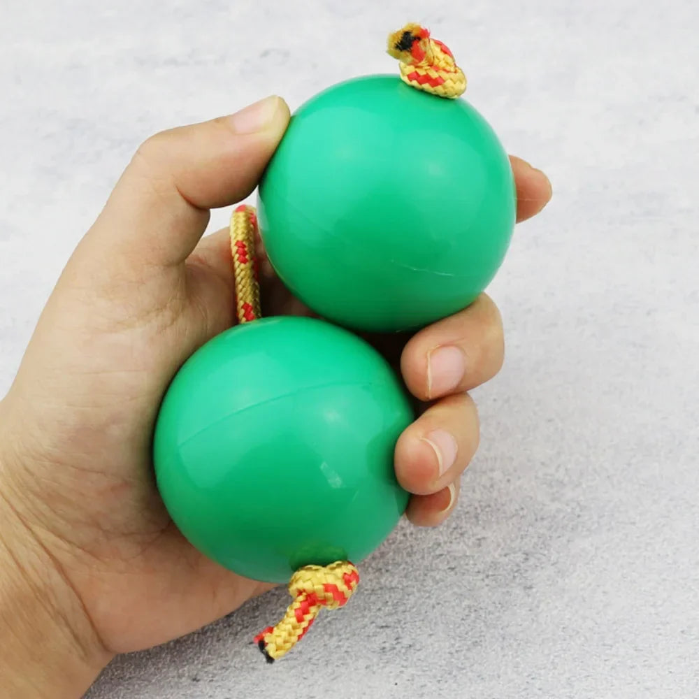 Two bright green glossy plastic african shaker kashaka rhythmic balls with red and yellow braided rope handles