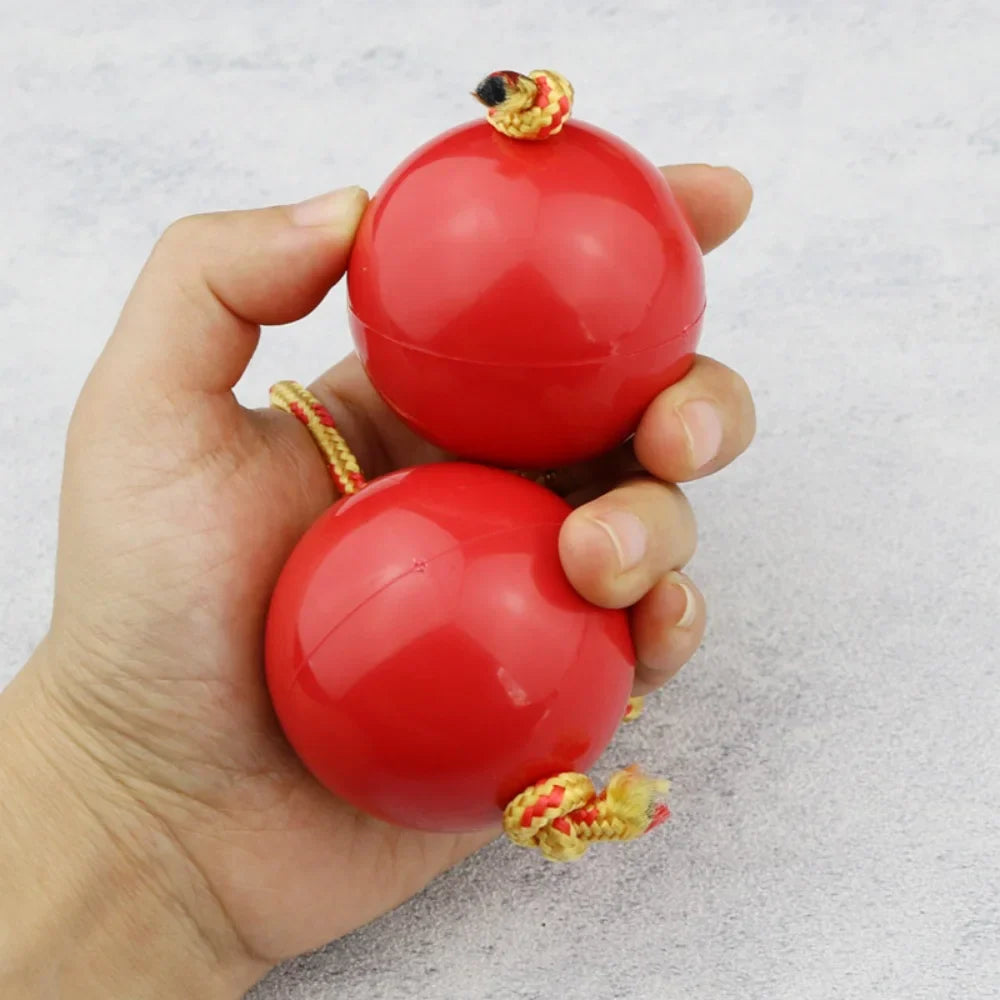 Red plastic gourd-shaped african shaker kashaka with yellow and red braided cords for rhythmic percussion play