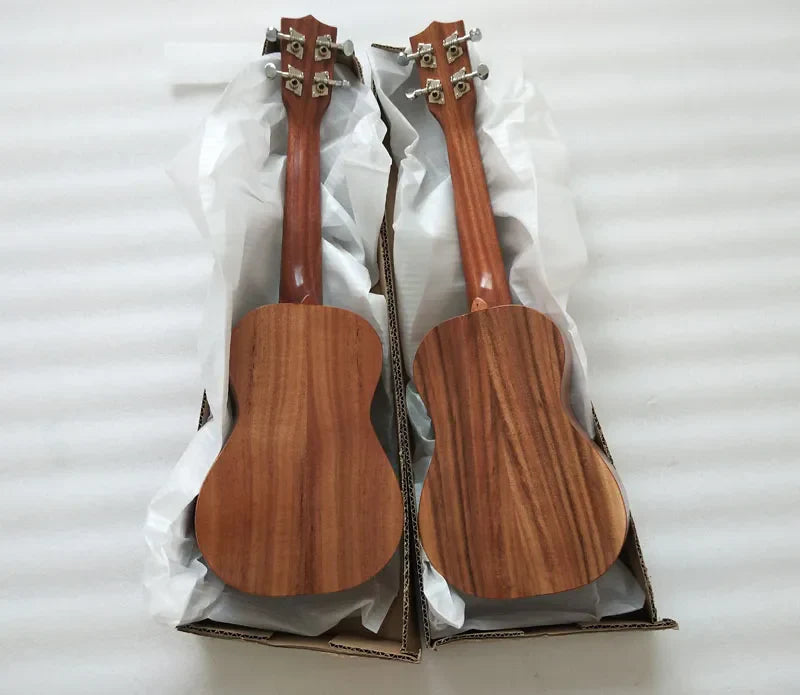 Two matching aiersi brand koa pili koko concert ukuleles with solid koa body warm reddish brown finish and silver tuning pegs