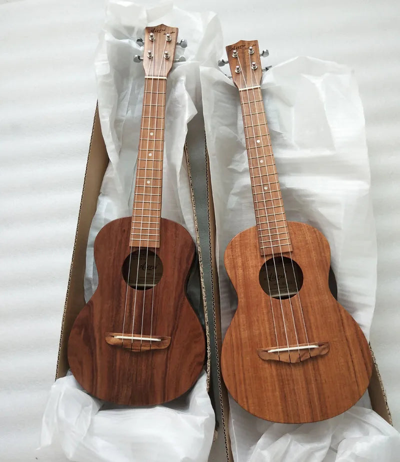Two professional handmade Aiersi koa pili koko concert ukuleles with solid koa body in darker brown and lighter tan hues