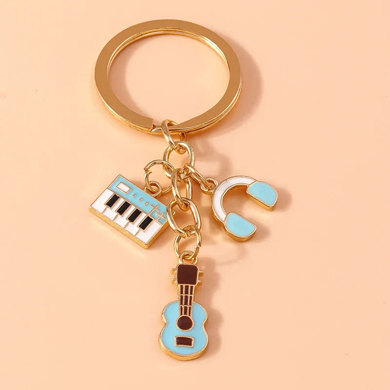 Gold-toned aihua alloy metal enamel musical instrument keychain with light blue keyboard, headphones, and guitar charms for diy handbag pendant