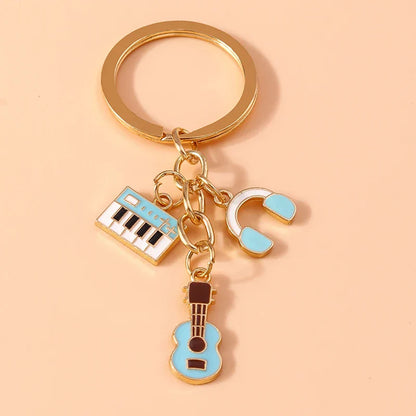 Gold-toned aihua alloy metal enamel musical instrument keychain with light blue keyboard, headphones, and guitar charms for diy handbag pendant