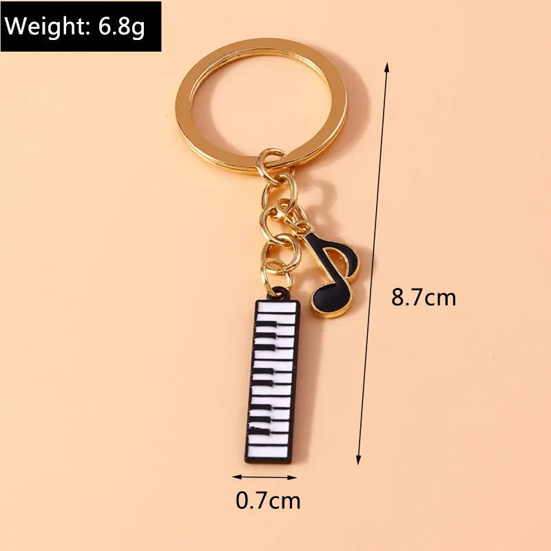 Gold-colored aihua alloy metal enamel musical instrument keychain with miniature piano keyboard and black music note pendant for diy handbag pendant