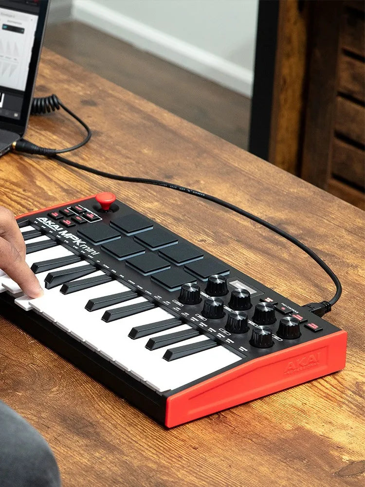 Black and red akai professional mpk mini play mk3 plus arranger music controller with white keys and black knobs