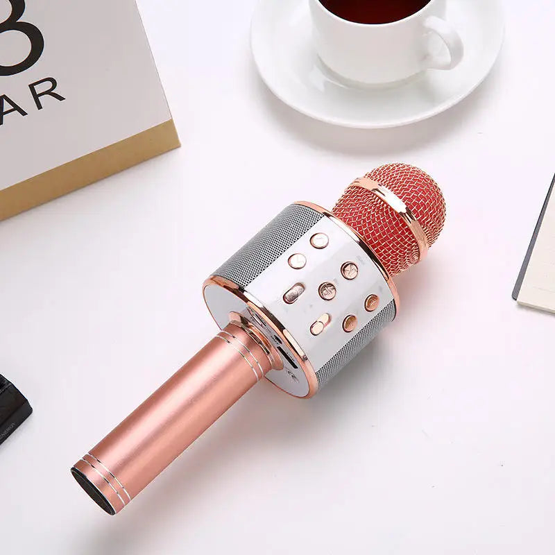Rose gold wireless karaoke microphone with red mesh grille and silver control panel featuring stable connection and multiple compatible devices