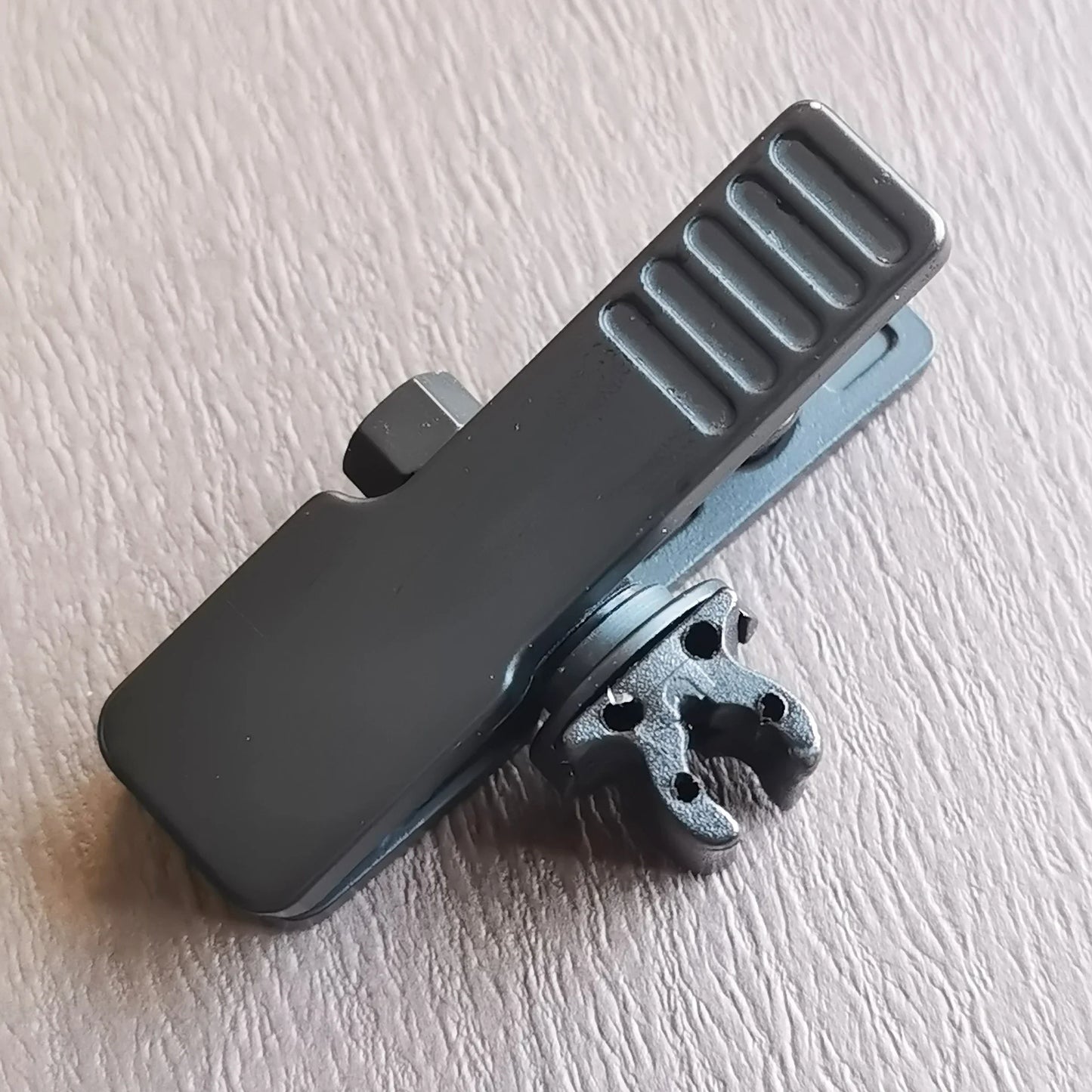 Black plastic musical instrument microphone clip with textured grip and intricate metal attachment for violin mic clamps stringed use