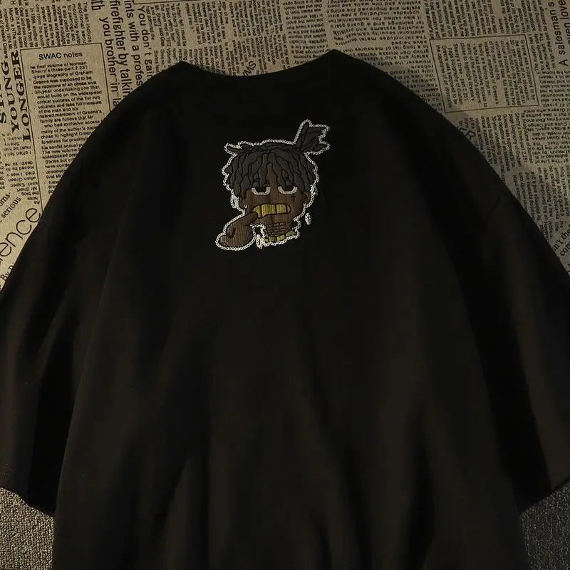 Black oversized short sleeve t-shirt with white embroidered cartoon dreadlocks and gold teeth for American hip hop fashion