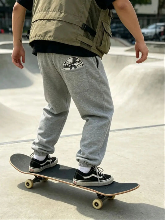 Gray sweatpants with circular graphic patch on back pocket featuring american hip hop personality design street trendy pants