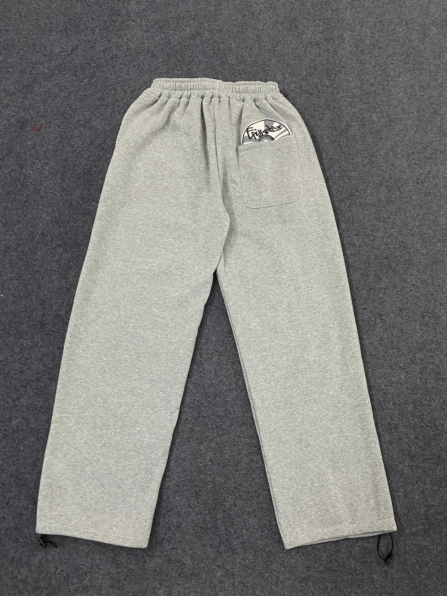 Gray heathered sweatpants with drawstring waist and side pockets showing back pocket logo in american hip hop street trendy pants