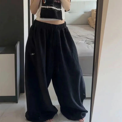 Black casual sweatpants with elastic waistband and embroidered logo in oversized korean streetwear style jogging pants high waist