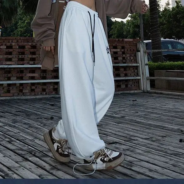 White loose-fitting american retro hiphop sweatpants with black drawstrings and small star emblem for casual wear