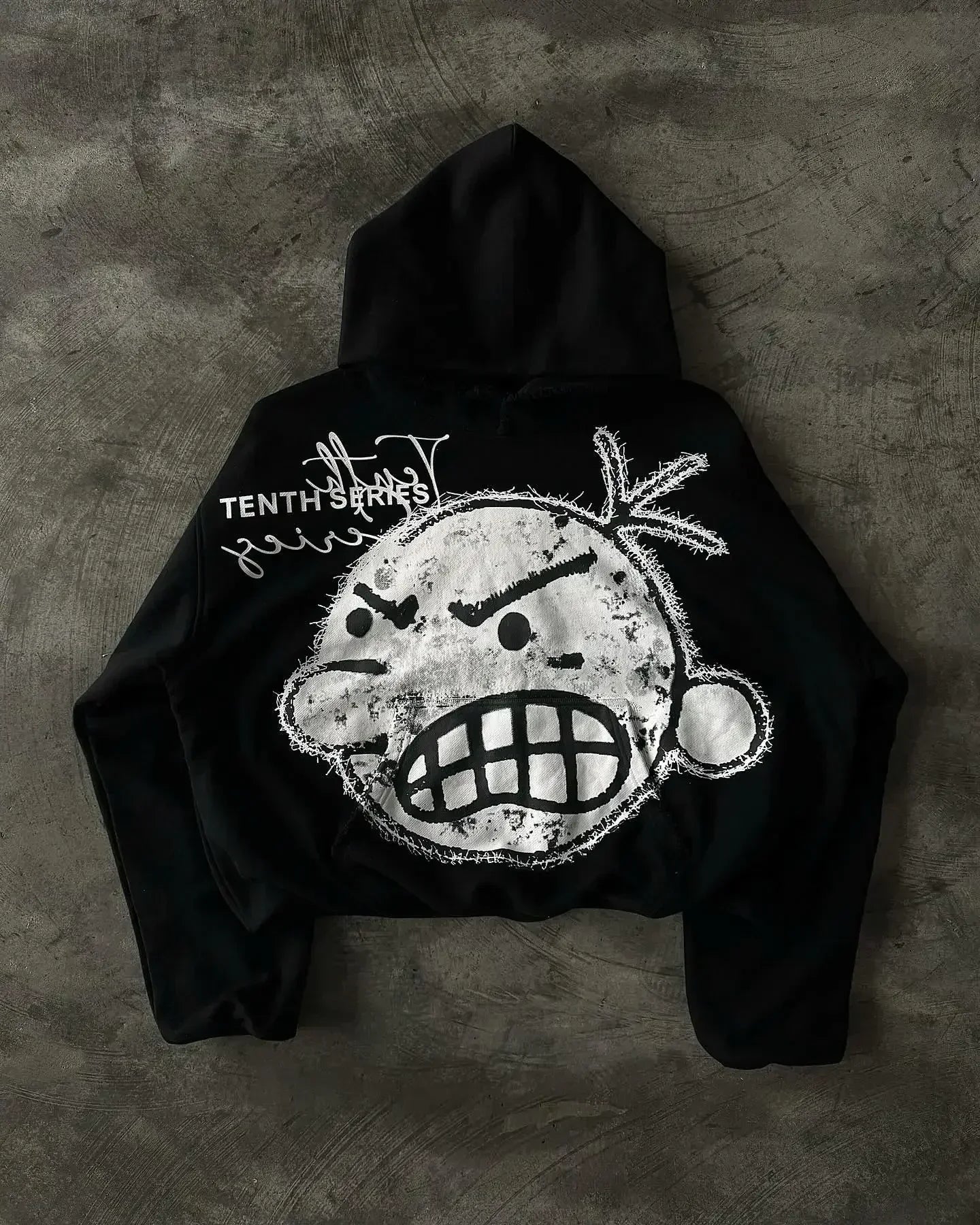 Black cropped american retro zipper hoodie featuring distressed white hip hop cartoon graphic and tenth series text