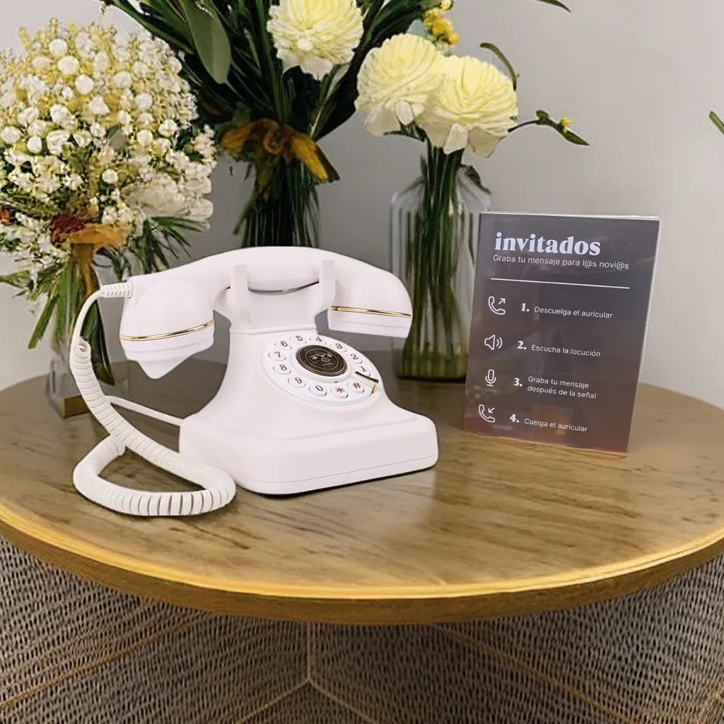 White rotary telephone with gold trim and coiled cord on wooden table for antique wedding audio tape recorders message