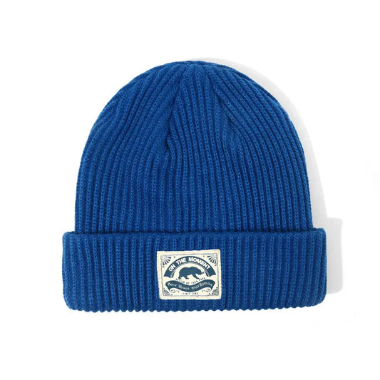 Royal blue ribbed knit beanie with folded cuff and white patch featuring bear silhouette for women hip hop melon cap fashion