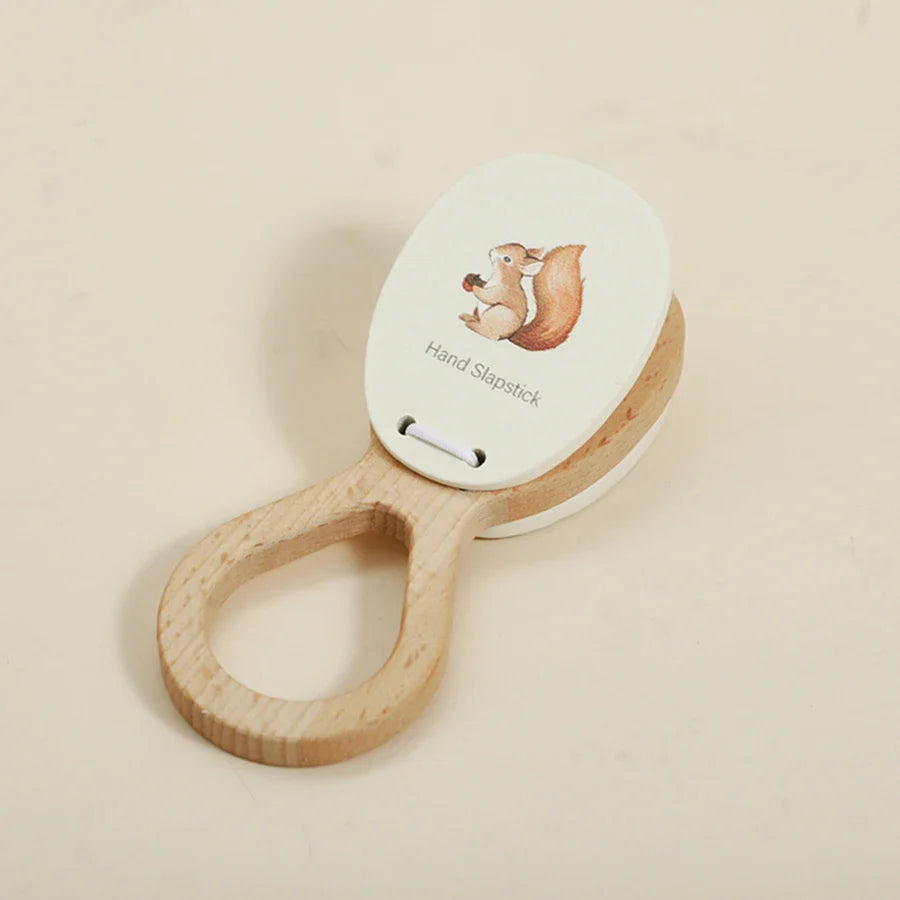 A wooden hand slapstick with a white oval face painted with a squirrel holding an acorn for baby musical toys educational instrument playthings