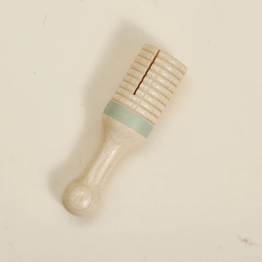 A light-colored wooden bear rattle with ribbed texture and mint green band as a baby musical toy educational instrument plaything