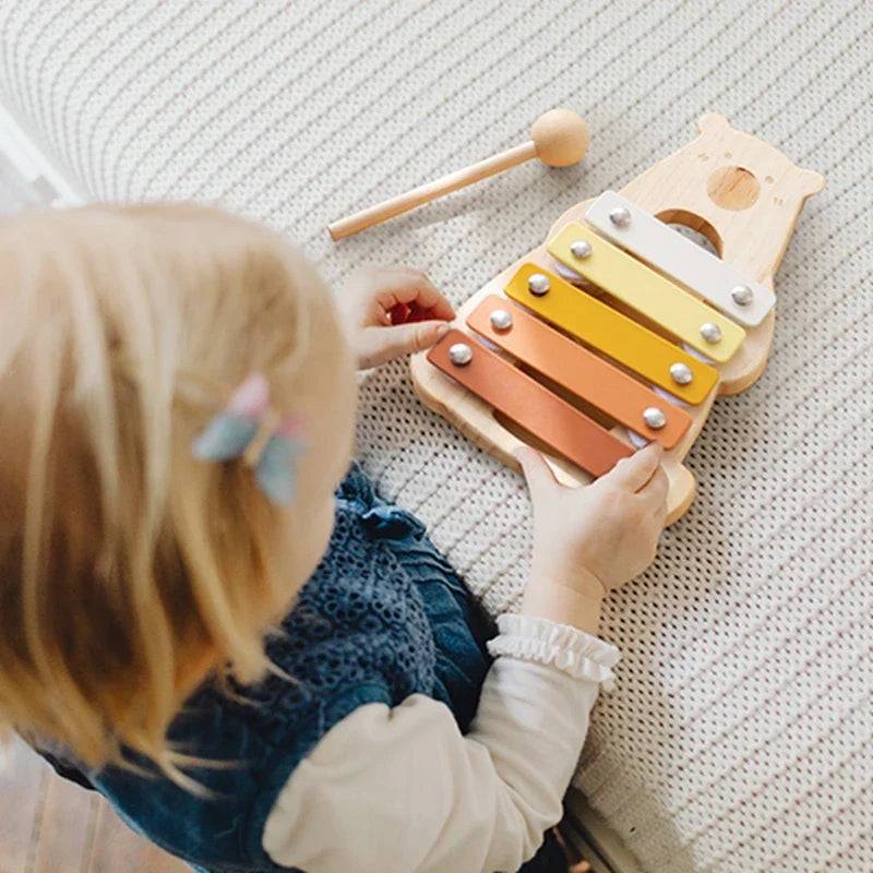 Wooden baby percussion music toy with colorful yellow and orange bars in a bear-shaped base for musical early education