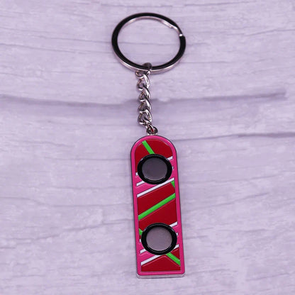 Pink enamel mcfly hoverboard keychain with retro green stripes and black cutouts fun accessory for sci-fi fans