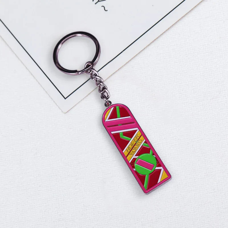 Vibrant pink and green enamel mcfly hoverboard keychain shaped like a delorean with yellow hotel bord text and silver ring