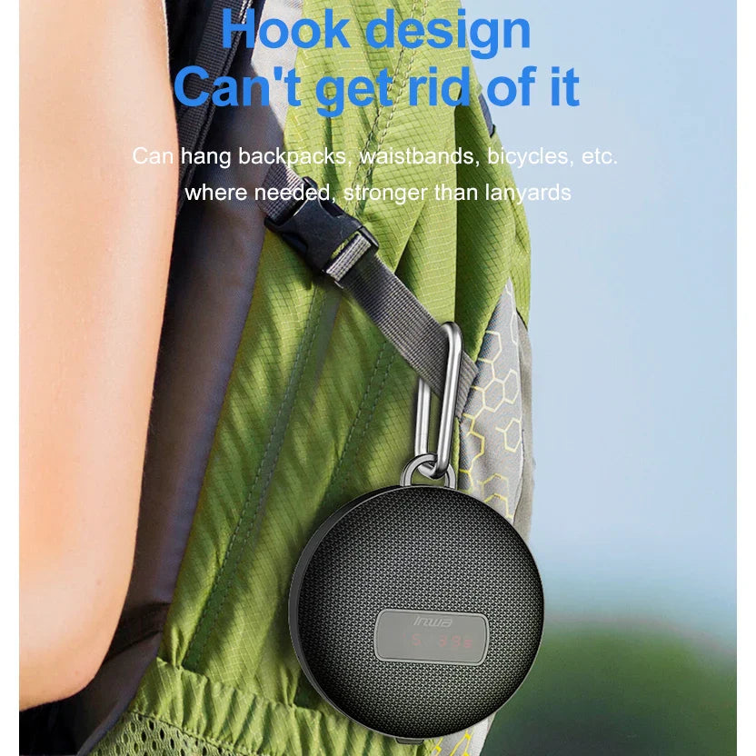 Black circular bicycle portable bluetooth speaker with textured grille and silver hook wireless mini subwoofer column