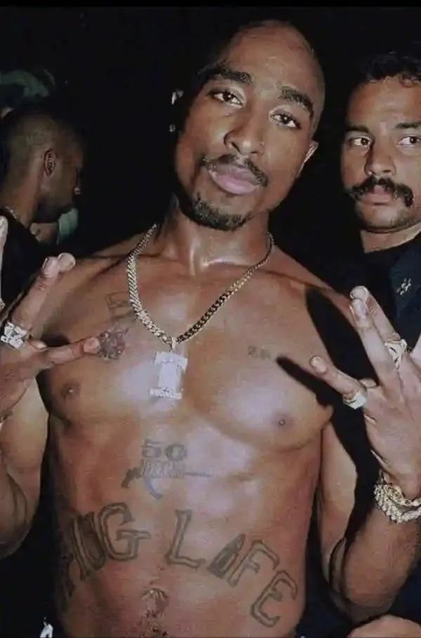 Gold chain necklace with rectangular pendant displayed with black and white pop hip hop rapper 2pac posters ships in business days