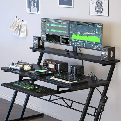 Black home studio desk for music production with two-tiered surface angled metal legs and built-in power outlet ideal for type beat music