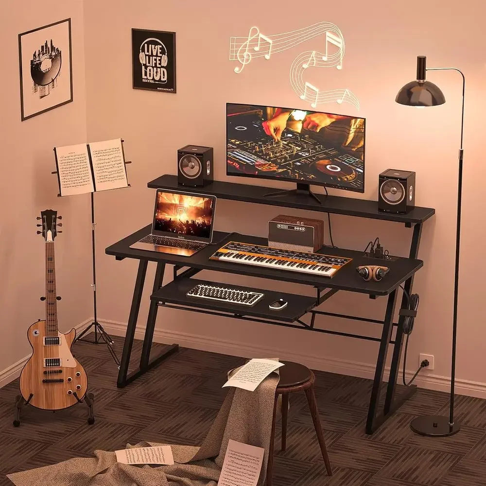 Black two-tiered music production desk with sleek metal legs, built-in shelves, keyboard tray, and power outlet for type beat music